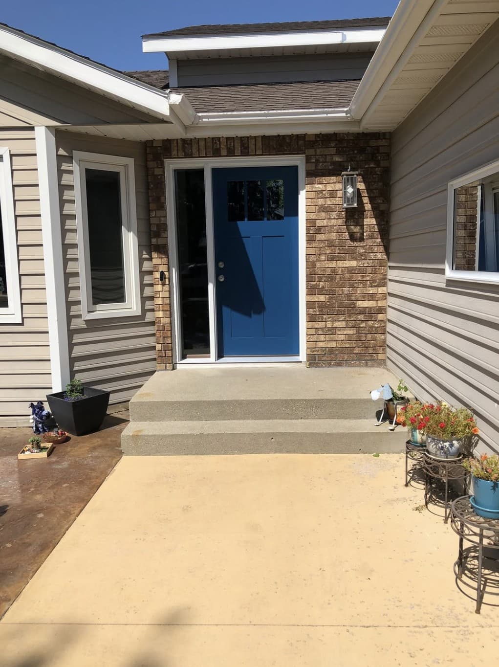 New blue craftsman entry door with a sidelight set in brick