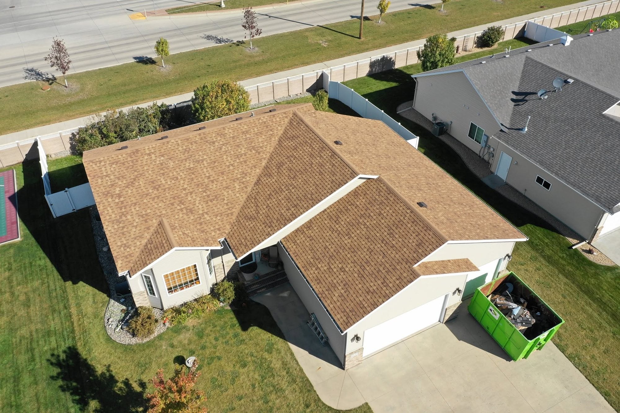 Ranch home with a new brown shingle roof after storm damage