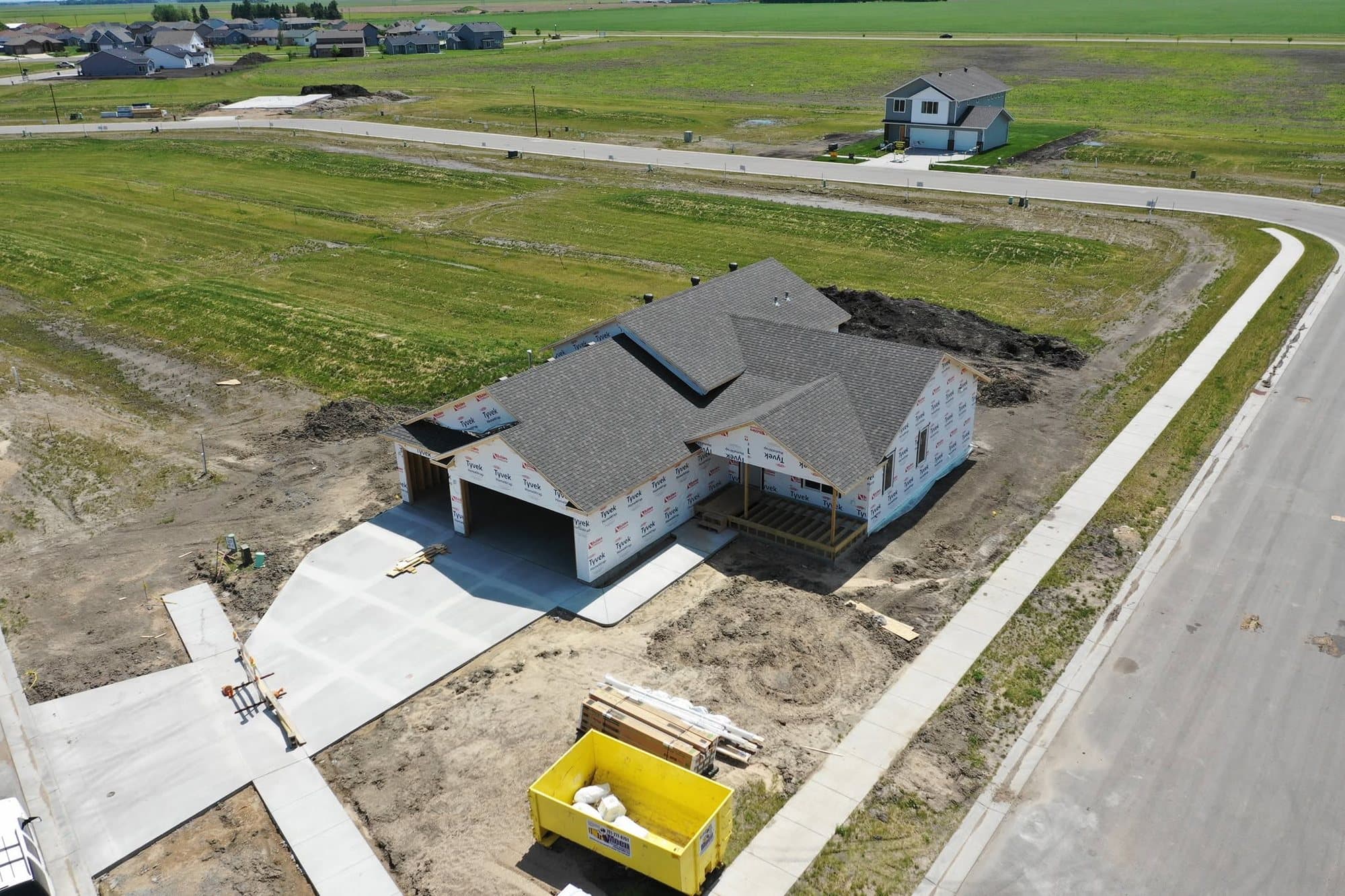 New home in a growing subdivision with its shingle roof finished before siding