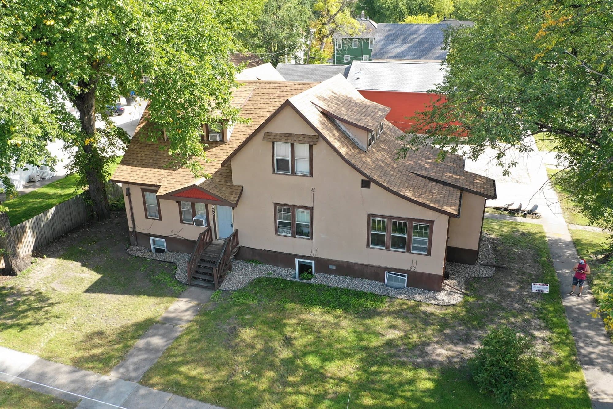 Front of the older two-story home with its complex new tan roof